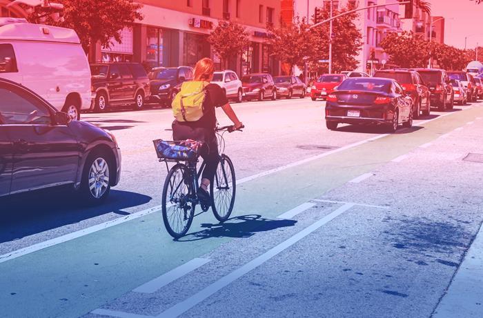 Woman riding bike on a busy street