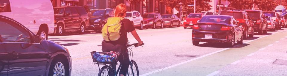 Woman Riding a bike on a busy street